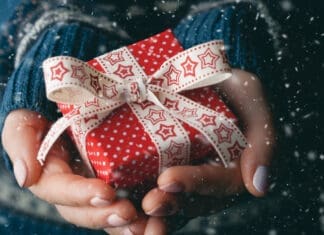Close up shot of female hands holding a small gift.